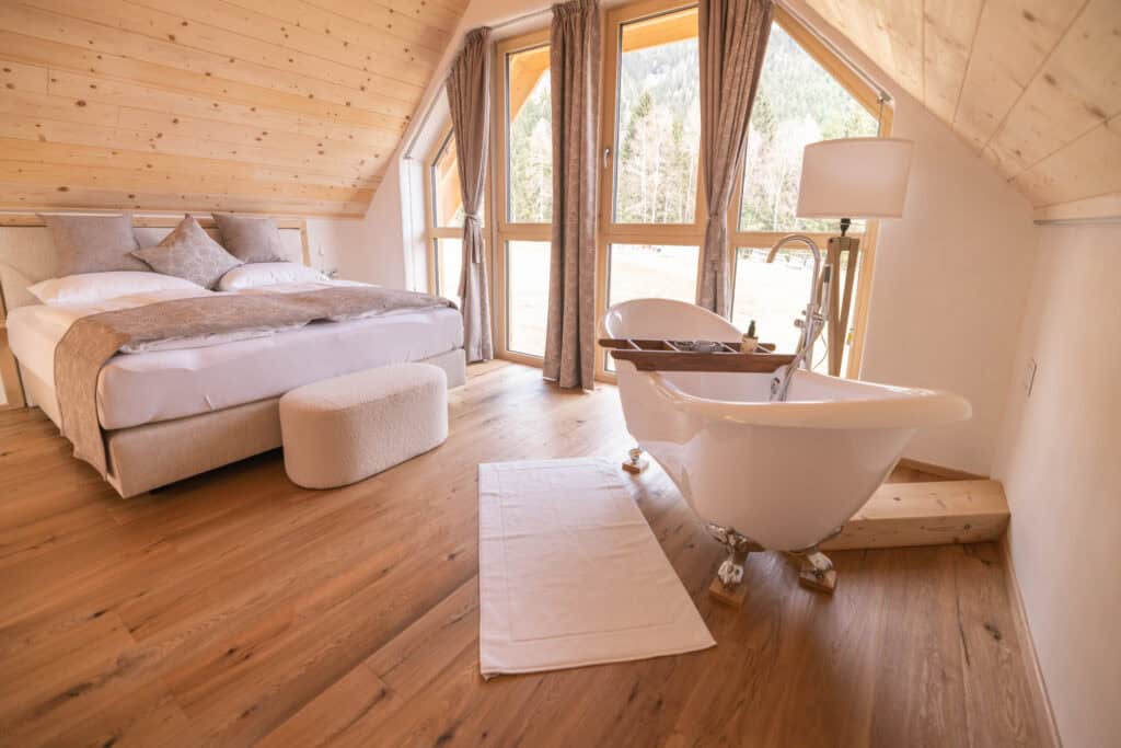 Boxspringbett und freistehende Badewanne mit Blick ins Grüne – Erholung mit Aussicht