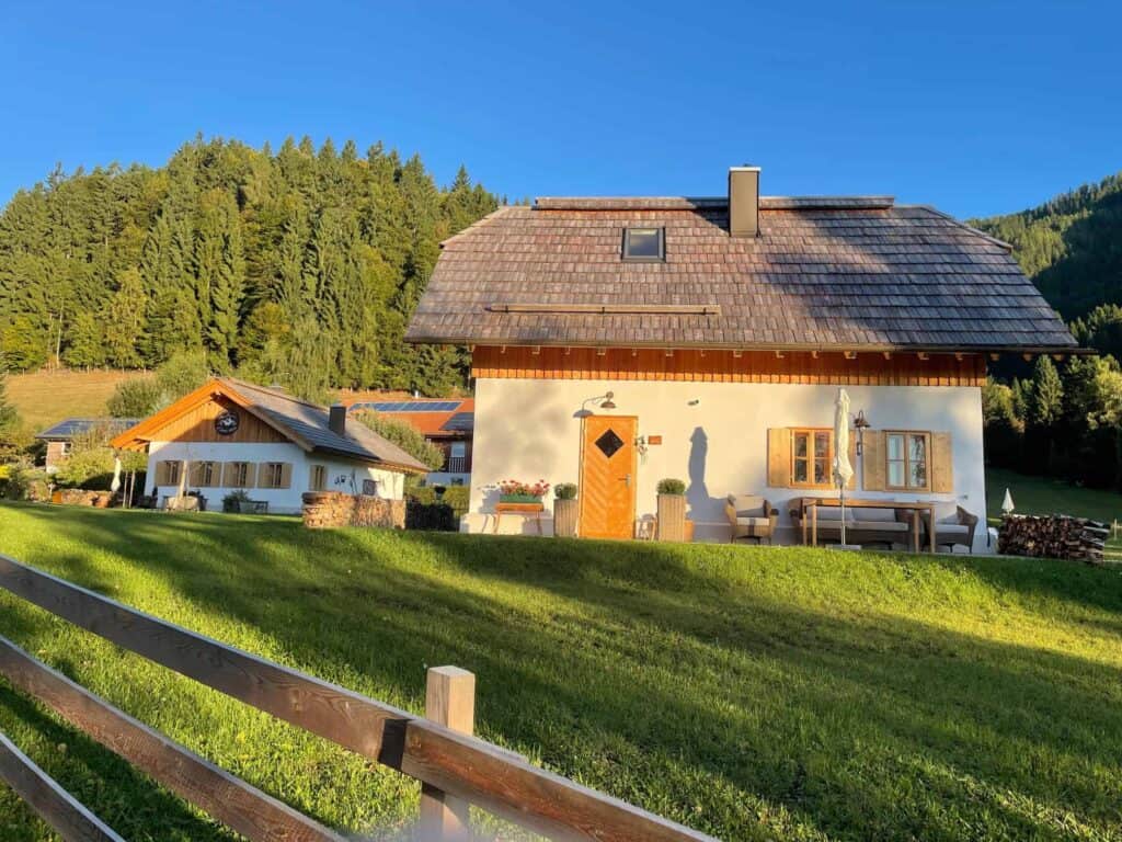 Gemütliches Landhaus im bäuerlichen Stil mit Balkon, Holzfenstern und Garten in ländlicher Umgebung.