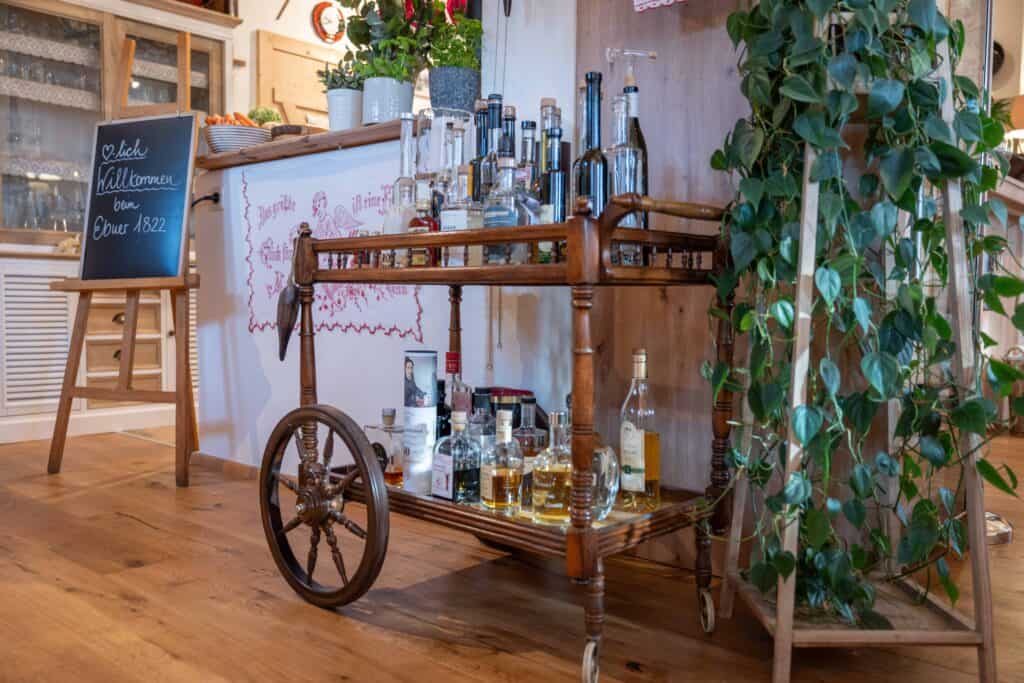 Dorfschenke at Ebner 1822 - Postazione di barista con liquori e bicchieri in un ristorante.