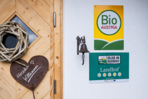 Bio-Austria- und Fünf-Blumen-Auszeichnung am Eingang von Ebner 1822 in Kärnten